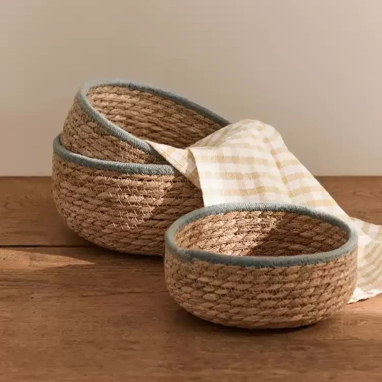 Natural woven seagrass storage baskets with blue-gray rims — view 1