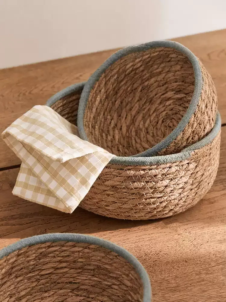 Natural woven seagrass storage baskets with blue-gray rims — view 2